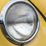 Classic car headlamp with chrome trim on a yellow body, featured in the January 2026 Quarterly Newsletter.