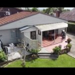 Home exterior showing structural transformation during a home renovation project, featuring a deck and backyard.